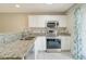 Modern kitchen with white cabinets, stainless steel appliances, and granite countertops at 6502 Whelan St, Englewood, FL 34224