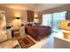 Bright bedroom with king-size bed and access to a balcony at 654 Bird Bay E Dr # 106, Venice, FL 34285
