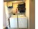 Laundry room with washer, dryer, and ample shelf space at 654 Bird Bay E Dr # 106, Venice, FL 34285