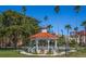 White gazebo with red tile roof, surrounded by lush landscaping and benches at 655 Crossfield Cir # 7, Venice, FL 34293