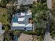Overhead shot of a home with a pool and patio, shaded by mature trees, offering a private outdoor living space at 705 Armada N Rd, Venice, FL 34285