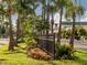 Neighborhood street view along an iron fence with tropical trees and businesses in the background at 705 Armada N Rd, Venice, FL 34285