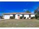 White house with brown roof, landscaping, and a two-car garage at 7148 Totem Ave, North Port, FL 34291
