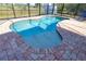 Freeform swimming pool with a shallow entry and brick pavers at 7148 Totem Ave, North Port, FL 34291