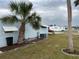 Side yard with palm trees and mobile home at 784 Londra Dr, Venice, FL 34285