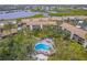 Aerial view of condo community with pool and lush landscaping at 832 Bird Bay Way # 113, Venice, FL 34285
