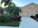 Tan two-car garage villa with mature landscaping and palm trees at 9019 Stone Harbour Loop, Bradenton, FL 34212