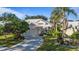 White house with tile roof, driveway, and palm trees in a sunny neighborhood at 1009 Harbor Town Dr, Venice, FL 34292