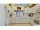 Well-equipped kitchen with white cabinets, ample counter space, and tile flooring at 1009 Harbor Town Dr, Venice, FL 34292