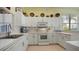 White kitchen with stainless steel appliances and breakfast bar at 1009 Harbor Town Dr, Venice, FL 34292