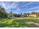 Spacious backyard with large lawn and house view at 107 Louella Ln, Nokomis, FL 34275