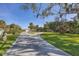 Long driveway leading to a single-story home with lush green lawn at 107 Louella Ln, Nokomis, FL 34275