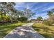 Long driveway leading to a house with tropical landscaping at 107 Louella Ln, Nokomis, FL 34275