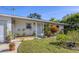 Ranch-style home features a charming front entrance and well-manicured landscaping at 107 Louella Ln, Nokomis, FL 34275