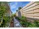 Landscaped side yard with a brick path and wooden fence at 107 Louella Ln, Nokomis, FL 34275