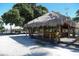 Outdoor Tiki bar with thatched roof, bar stools and a wooden bar at 107 Louella Ln, Nokomis, FL 34275