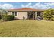 Home's backyard features a grassy area and screened patio at 11601 Parrotfish St, Venice, FL 34292
