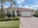 House exterior with tile roof, landscaping, and brick driveway at 11601 Parrotfish St, Venice, FL 34292