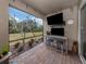 Covered patio with TV and seating area overlooking the backyard at 11601 Parrotfish St, Venice, FL 34292