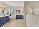 Spa-like bathroom with blue vanities, soaking tub, and walk-in shower at 11678 Aucilla Dr, Venice, FL 34293