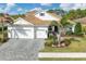 White two-story house with a gray brick driveway and palm trees at 11678 Aucilla Dr, Venice, FL 34293