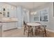 Bright kitchen with white cabinets, breakfast nook, and view into hallway at 11678 Aucilla Dr, Venice, FL 34293