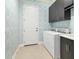 Laundry room with washer, dryer, stylish wallpaper, and dark cabinets at 11678 Aucilla Dr, Venice, FL 34293