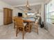 Bright dining area with wooden table and chairs, adjacent to living room at 12198 Wakulla Pl, Venice, FL 34293