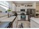 White kitchen with granite countertops and stainless steel appliances at 12198 Wakulla Pl, Venice, FL 34293