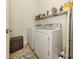 Functional laundry room with washer, dryer, and storage shelves at 12198 Wakulla Pl, Venice, FL 34293