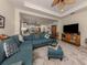 Open concept living room with teal sectional sofa and adjacent kitchen at 12198 Wakulla Pl, Venice, FL 34293