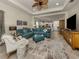 Open concept living room with teal sectional sofa and adjacent kitchen at 12198 Wakulla Pl, Venice, FL 34293