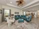 Open concept living room with teal sectional sofa and adjacent kitchen at 12198 Wakulla Pl, Venice, FL 34293