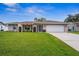Single-story home with a landscaped lawn and attached garage at 1236 Pinebrook Way, Venice, FL 34285