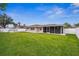 Back exterior view of the house showing the screened patio and the backyard at 1236 Pinebrook Way, Venice, FL 34285