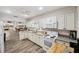 Bright kitchen features white cabinets, modern appliances, and wood-look flooring at 1236 Pinebrook Way, Venice, FL 34285