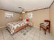 Bedroom with a floral-print bed, chair, and tiled flooring at 1300 Indus Rd, Venice, FL 34293