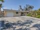 Yellow ranch home with a white garage door and driveway at 1300 Indus Rd, Venice, FL 34293