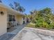Ranch-style home with a covered patio, mature landscaping, and a spacious driveway at 1300 Indus Rd, Venice, FL 34293