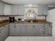 Kitchen features gray cabinets, granite countertops and a breakfast bar at 1300 Indus Rd, Venice, FL 34293