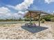 Picnic table under a wooden shelter near basketball courts at 1300 Indus Rd, Venice, FL 34293