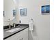 Modern bathroom with a dark countertop and coastal art at 13072 Steinhatchee Loop, Venice, FL 34293