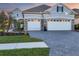 Two-story home with a three car garage and landscaped yard at 13072 Steinhatchee Loop, Venice, FL 34293