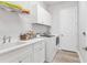 Bright laundry room with white cabinets and shelving at 13072 Steinhatchee Loop, Venice, FL 34293