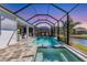 Enclosed pool and spa with a lake view at dusk at 13072 Steinhatchee Loop, Venice, FL 34293