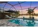 Enclosed pool and spa with lake view and sunset at 13072 Steinhatchee Loop, Venice, FL 34293