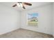 Well-lit bedroom with a window, ceiling fan, and carpet flooring at 13421 Gershwin Ln, Port Charlotte, FL 33981