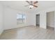 Large bedroom with wood-look floors, ceiling fan, and window at 13421 Gershwin Ln, Port Charlotte, FL 33981