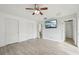 Primary bedroom with wood-look floors, ceiling fan and large TV at 13421 Gershwin Ln, Port Charlotte, FL 33981