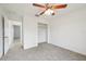 Bright bedroom with ceiling fan, carpet, and access to hallway at 13421 Gershwin Ln, Port Charlotte, FL 33981